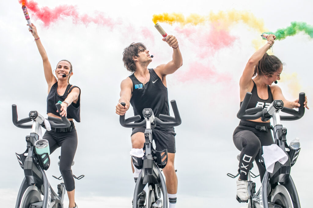 three indoor cycling people on Stages bikes indoor cycling with color smokers