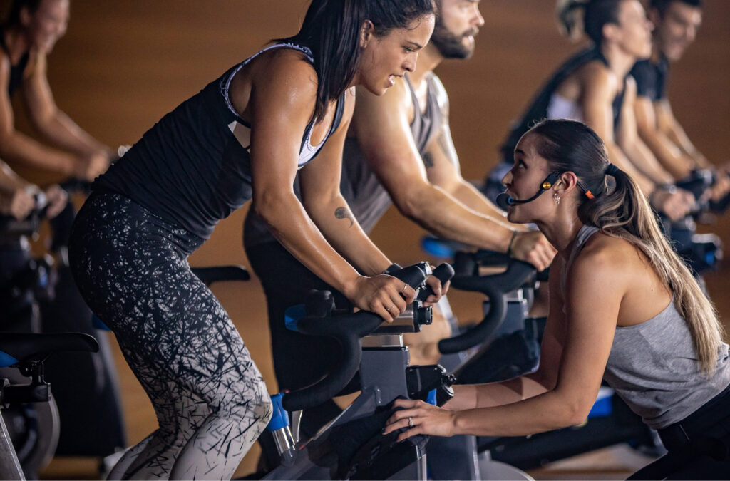 Indoor cycling class instructors instructing