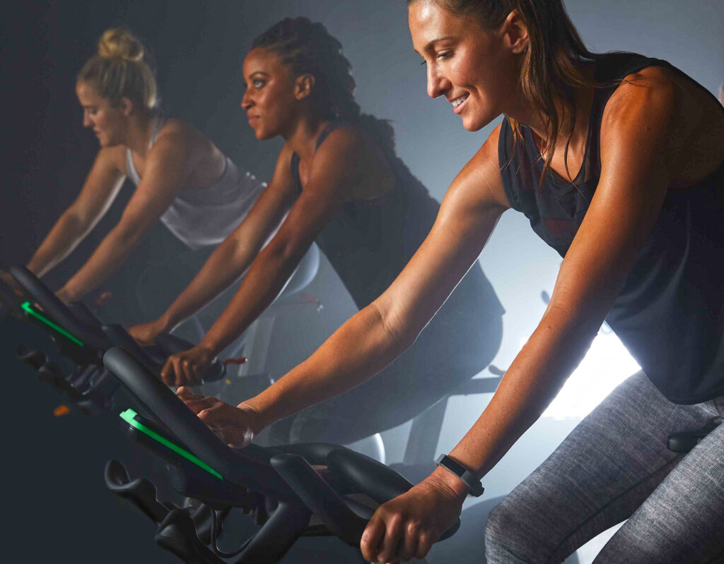 three beautiful young girls at indoor cycling class