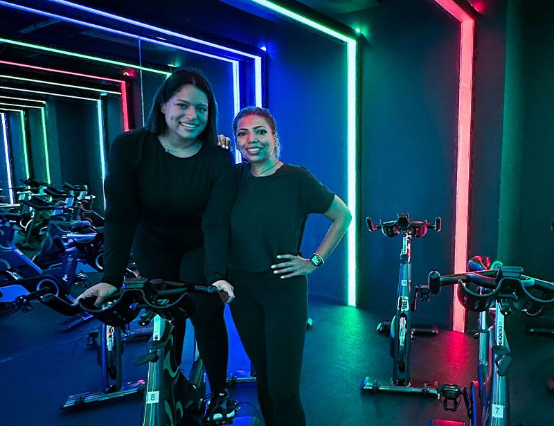 Two girls in a colorful indoor cycling studio in saudi arabia